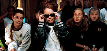 A gif from The Parent Trap showing Lindsay Lohan removing a pair of black sunglasses and put them on her head
