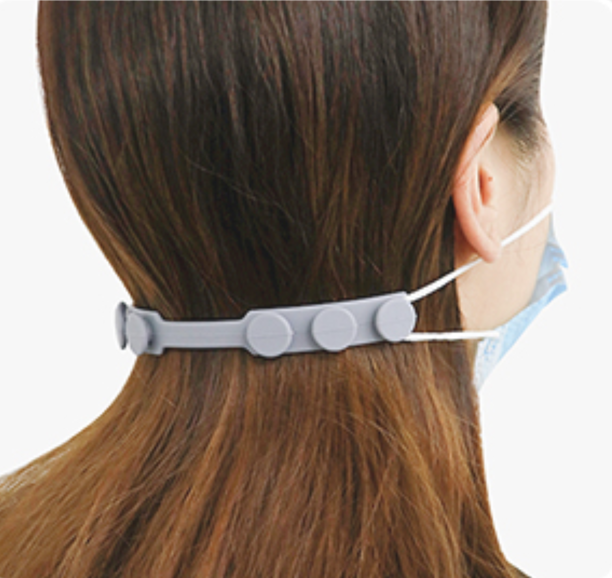 A model wearing a mask that is pulled together around the back of their head by the silicone ear saver, which has three different toggles on the back for sizing 