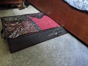 One under bed organizer packed with close pulled out from under a bed in a customer's home