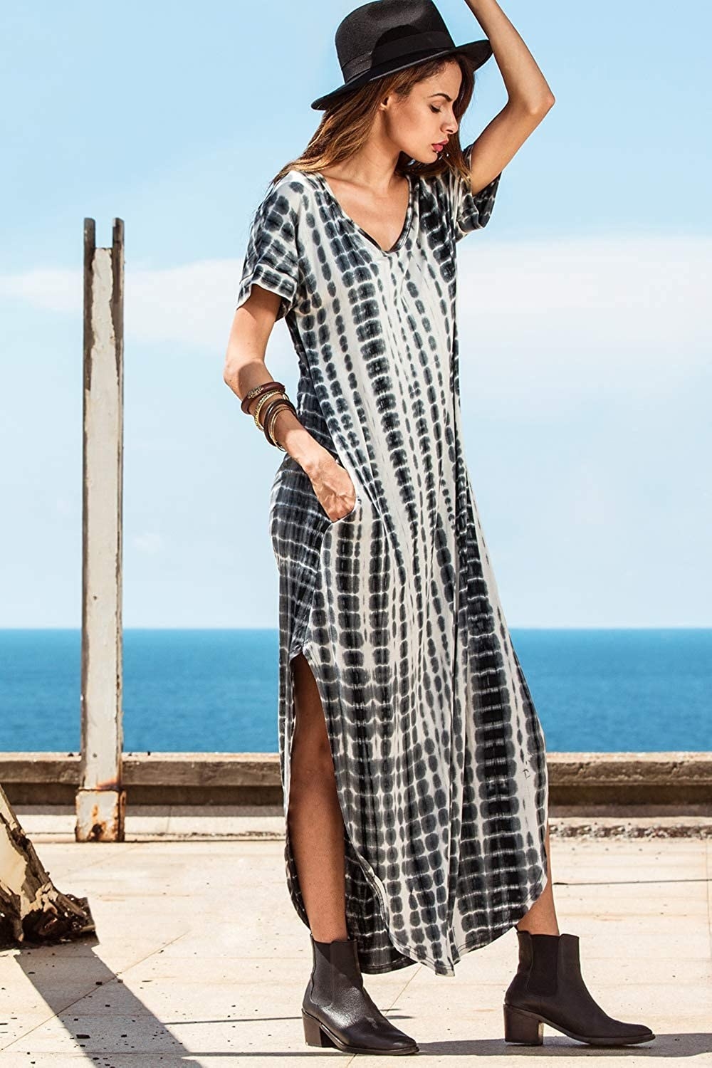 An ankle length dress made of jersey knit material with a mid-thigh hitting slit up both sides. It has short sleeves, pockets, and a V-neck collar. 
