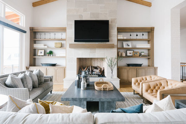 A large living room uses a tiled-fireplace as the focal point