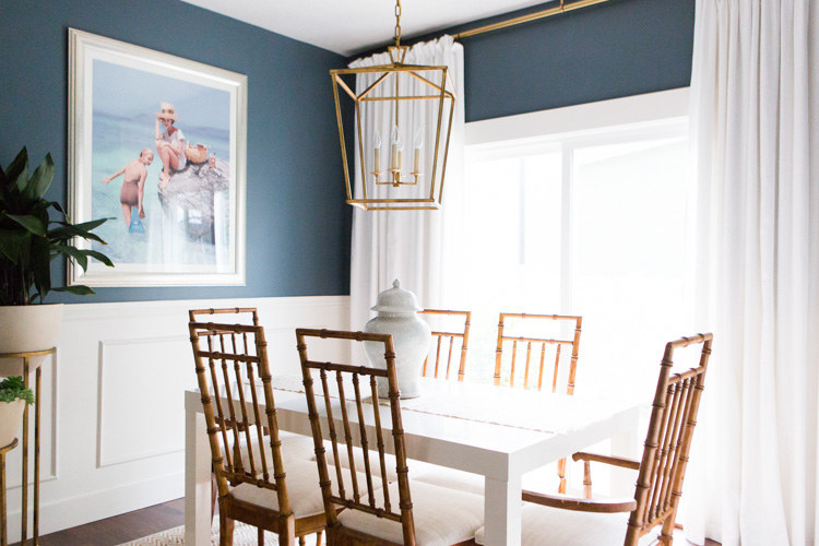 A dining room with a large pendant light fixture hanging over the table