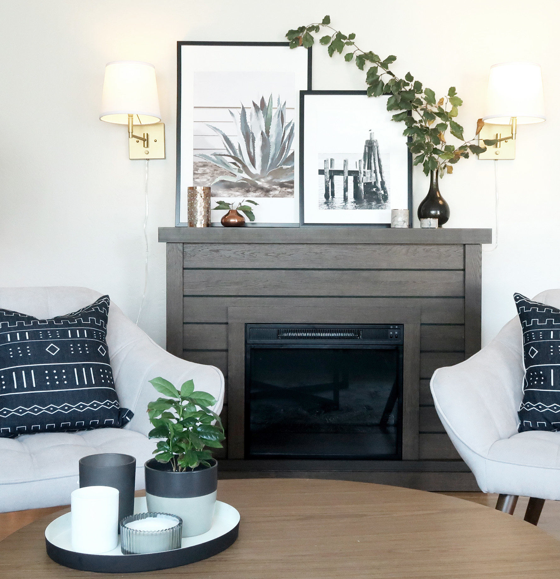 A faux fireplace, with decor on its mantle, is the focal point between two armchairs