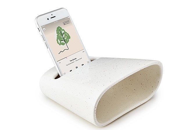 An iPhone playing iTunes sits in the ceramic phone amplifier