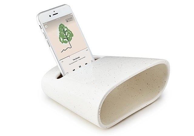 An iPhone playing iTunes sits in the ceramic phone amplifier