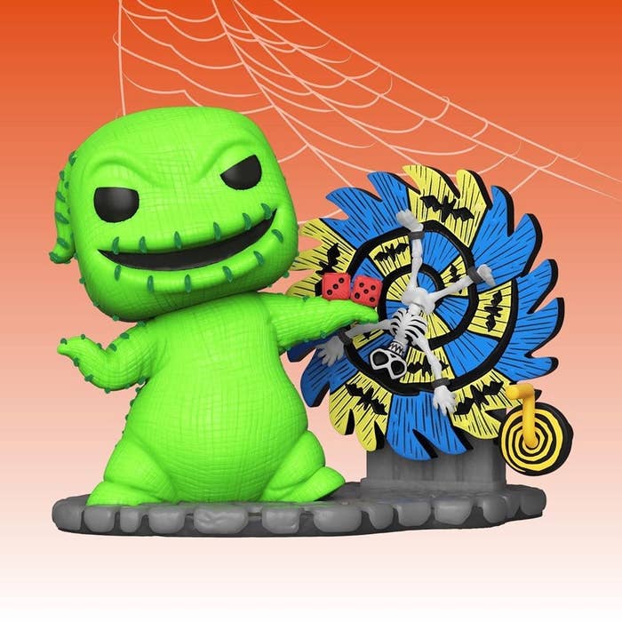 a green oogie boogie figure standing next to a spinning blue and white wheel with dice in hand and a skeleton in the middle