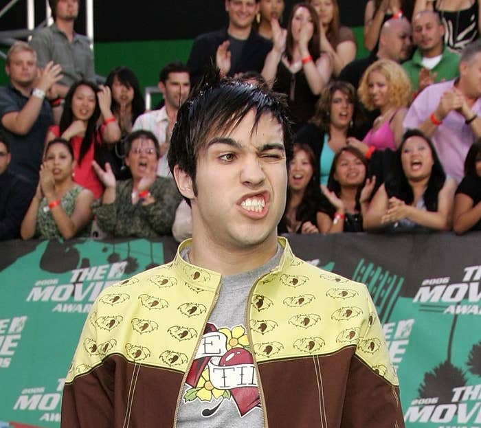 Pete Wentz on a red carpet with flat ironed bangs and making a side grunt face