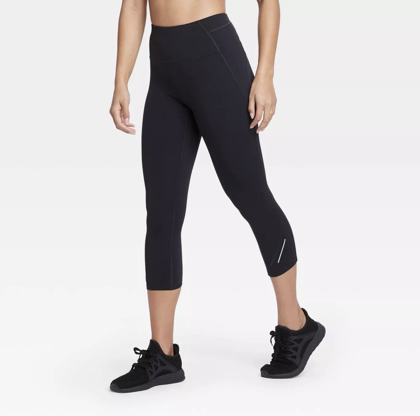 A model wearing a pair of black leggings that hit at the calf