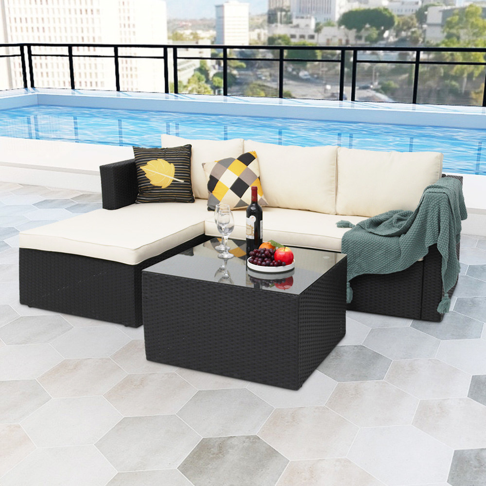 a white outdoor sectional couch with a black woven coffee table