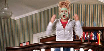 Hilary Duff as Lorraine in Cheaper by the Dozen stands in front of a bannister with a green face mask on. She gestures in surprise