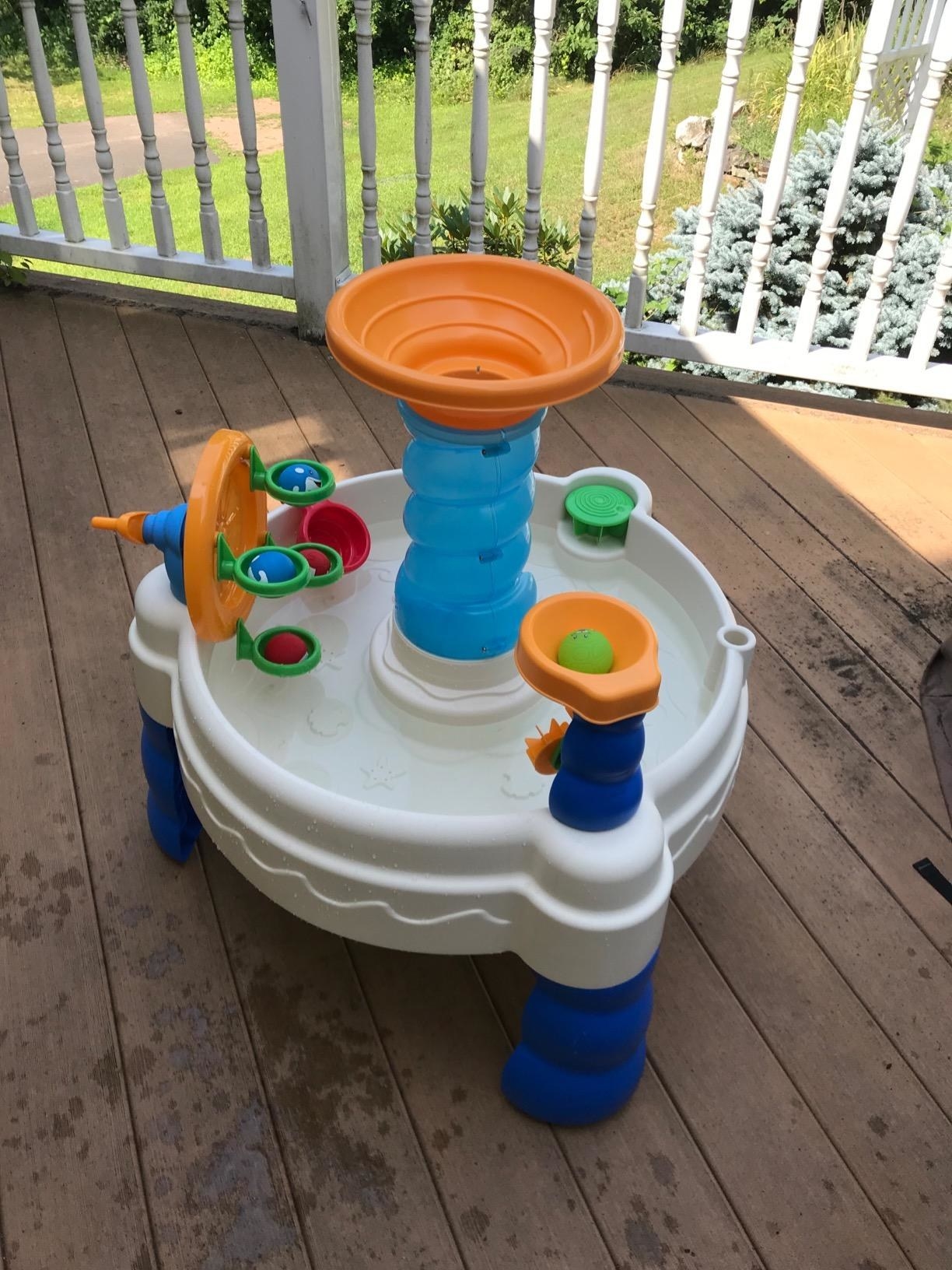 A white and blue plastic water table with multi-colored accents