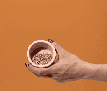 gif of a model&#x27;s hands putting the lid on the pink grinder and twisting it