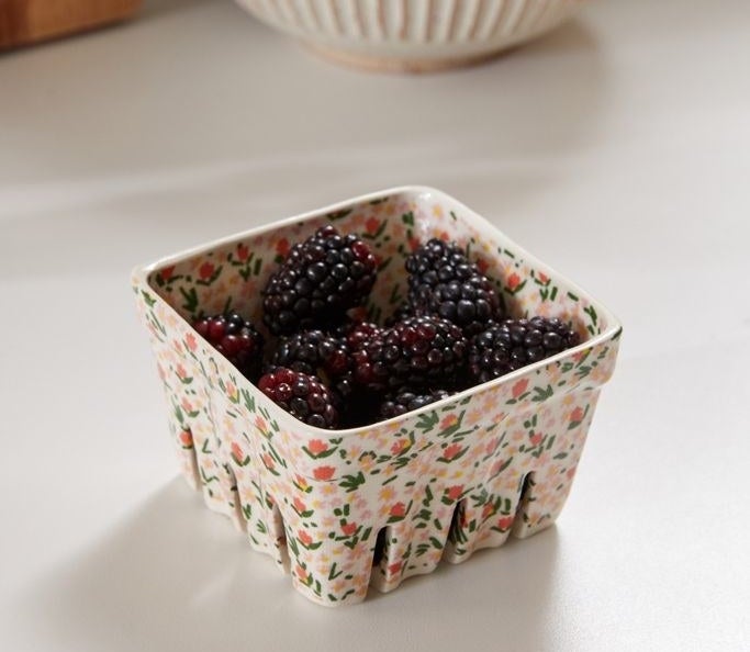 The dish that looks like a berry container in white with small flowers drawn all over it