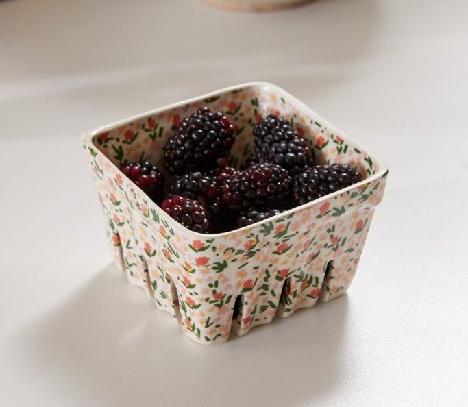 The dish that looks like a berry container in white with small flowers drawn all over it