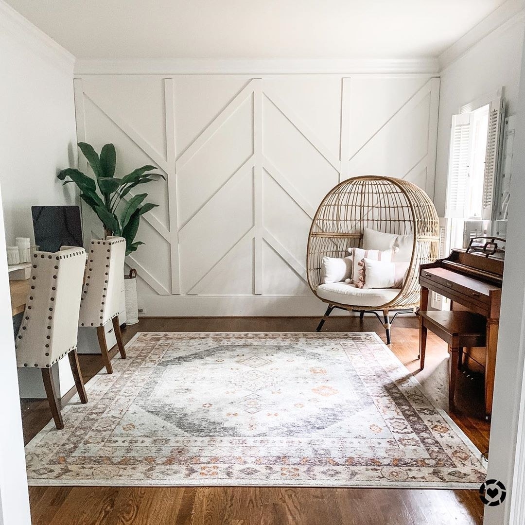 A living space with all white walls, with one wall turned into a board and batten wall