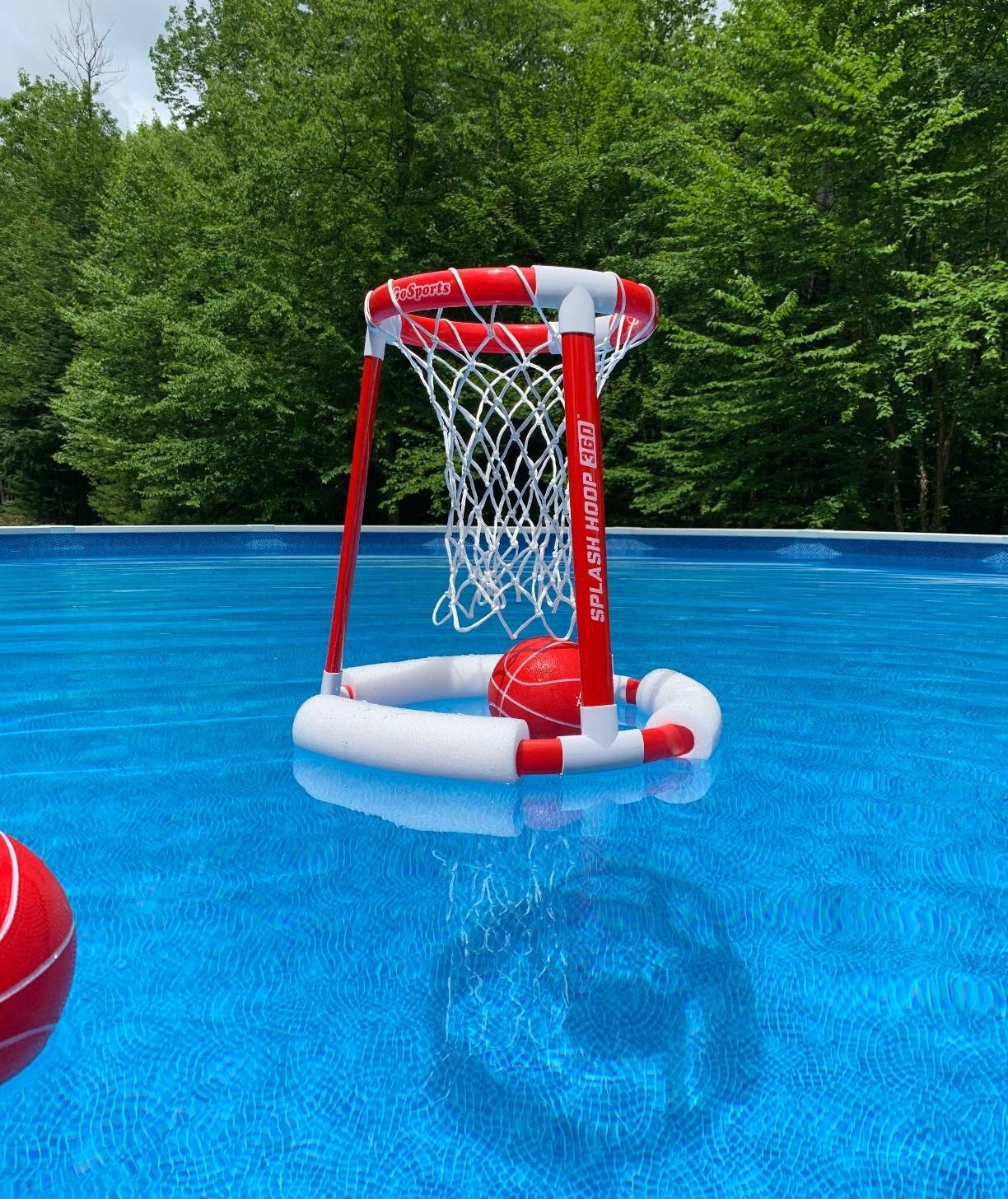 A white and red floating basketball hope in a pool 
