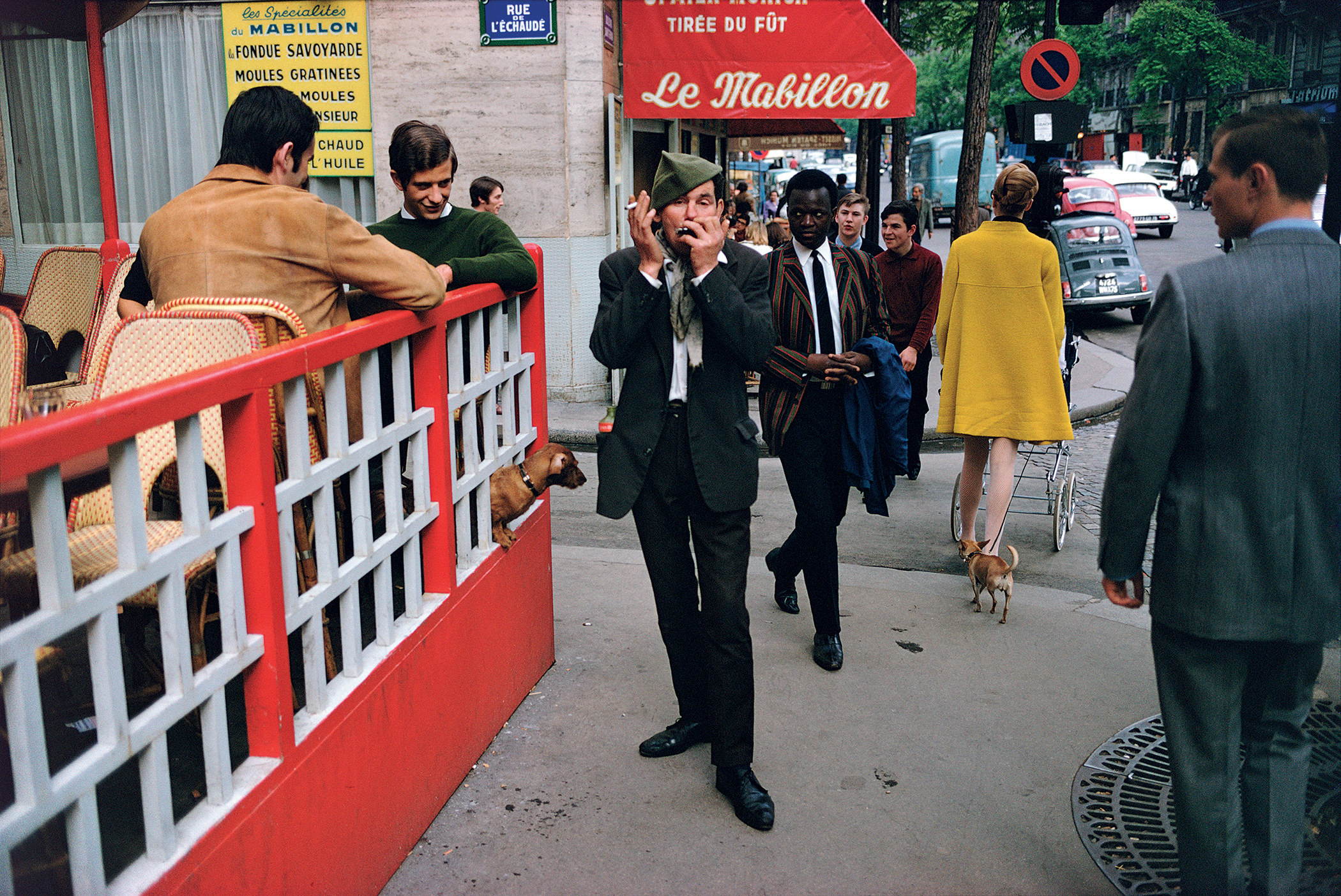 A man plays harmonica on a crowded city street