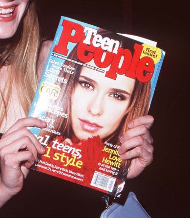 A cropped photo of Kirsten Dunst holding up a Teen People with Jennifer Love Hewitt on the cover.