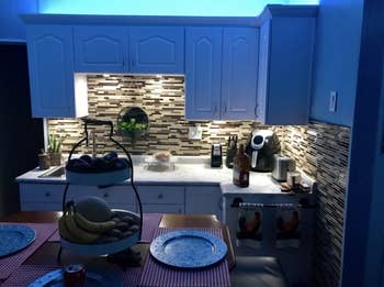 A kitchen with blue LED lights installed in the cabinets 