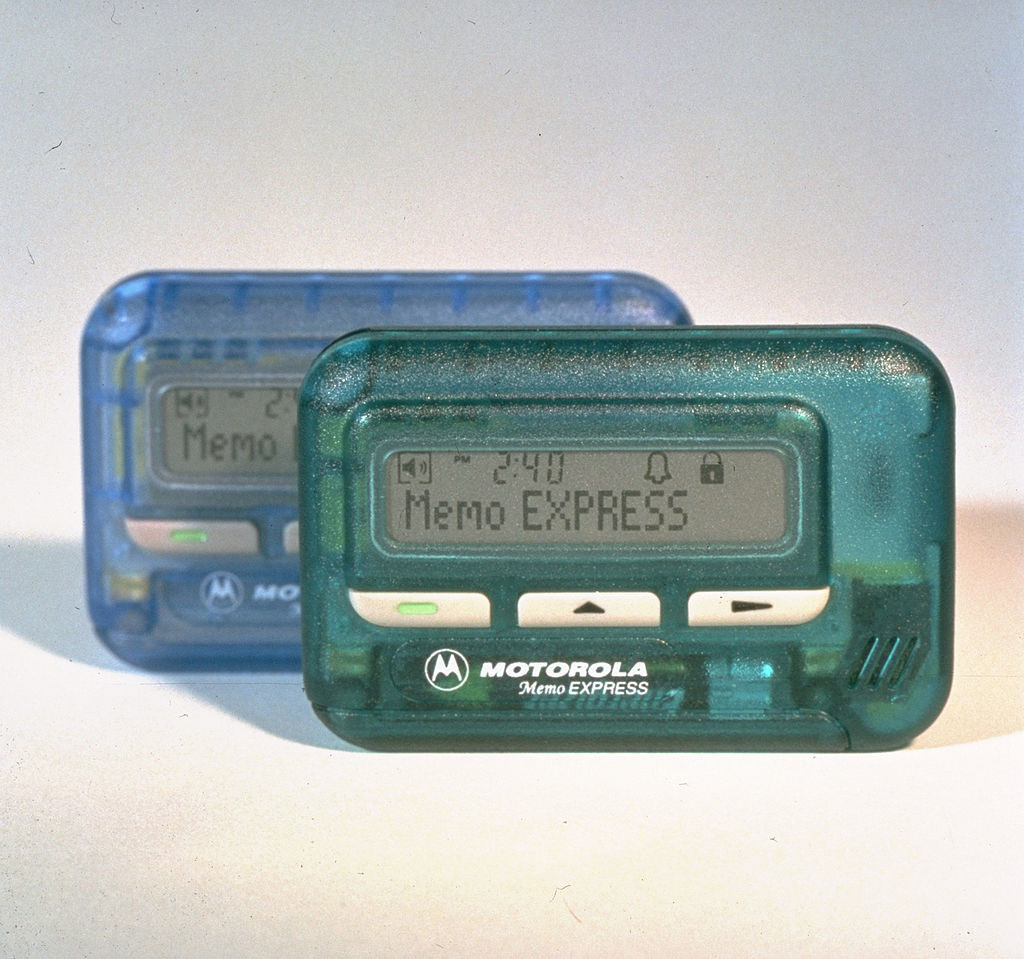 A photo of two Motorola pagers, one in baby blue and one in sea green.