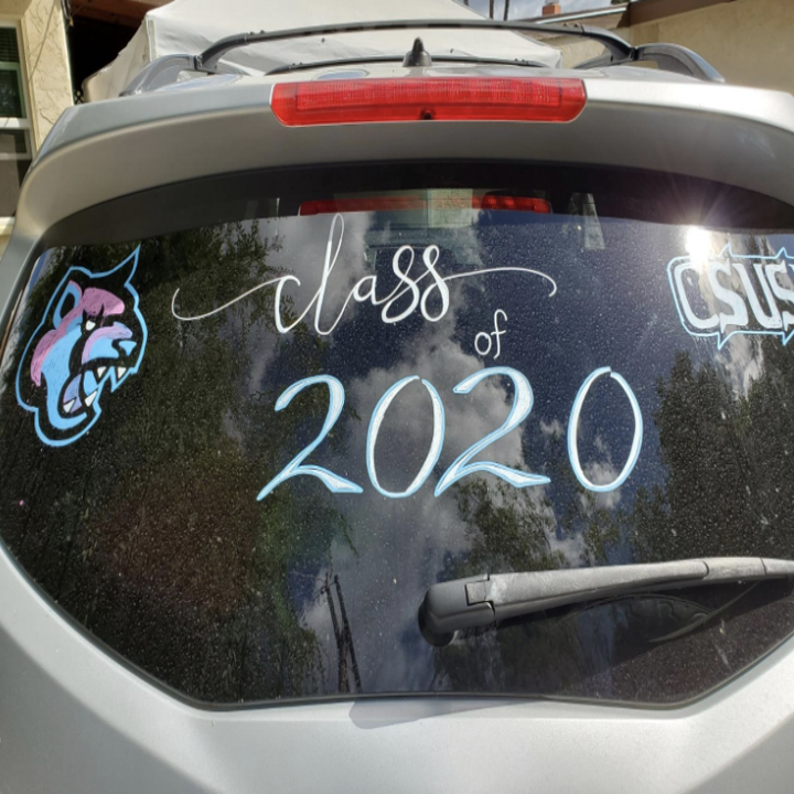 A car window with "class of 2020" and the mascot drawn on it 