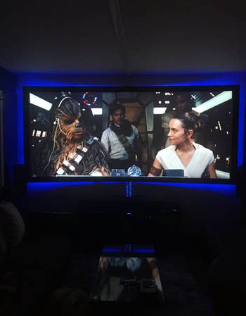 A tv playing star wars backlit with blue light 