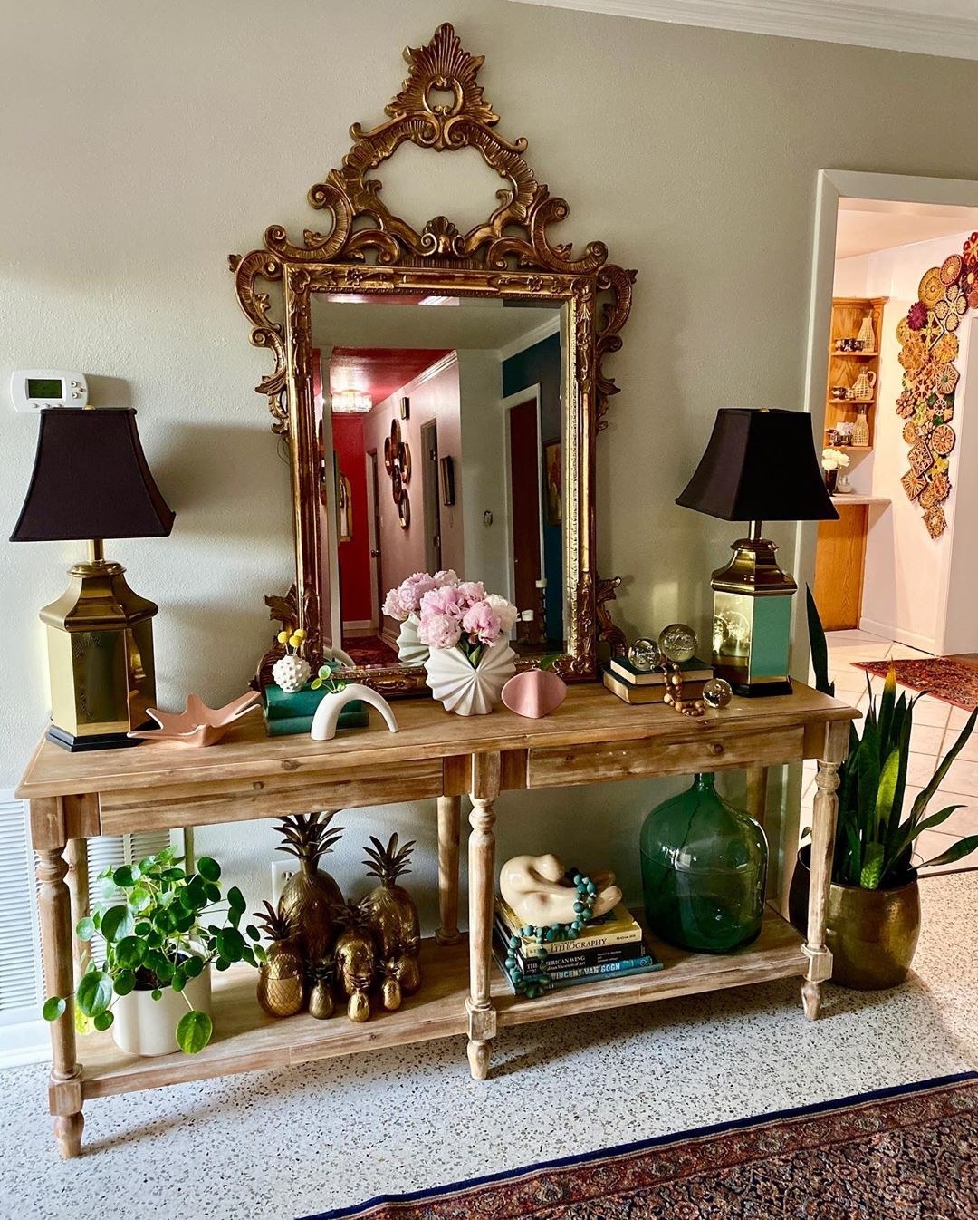 A large, ornate mirror sits on a console table as a focal point