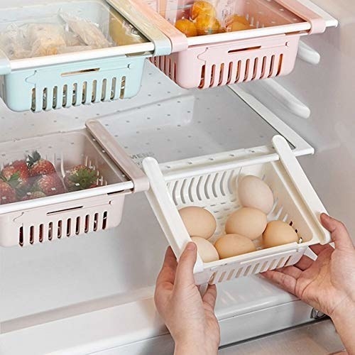 Some eggs and fruits organised neatly in the fridge with the organising trays.