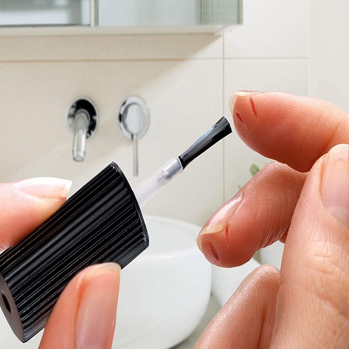 A person applying skin crack care to their index finger