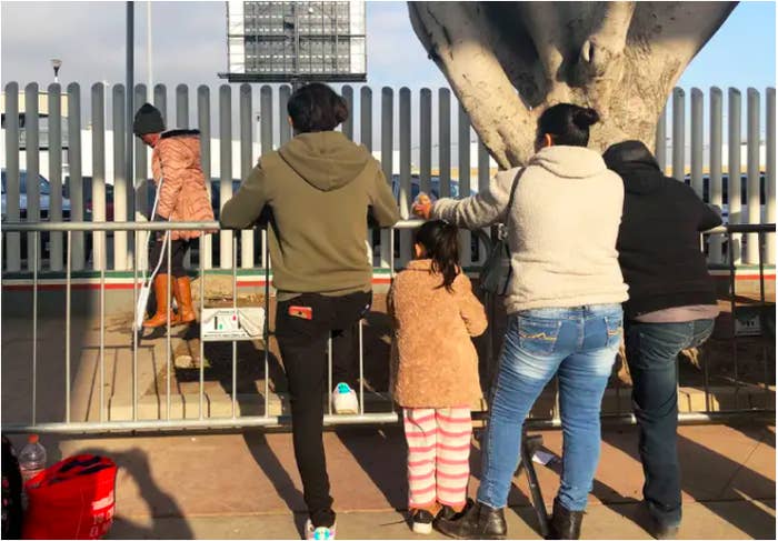 People seeking asylum in the US wait at the border crossing bridge in Tijuana, Mexico