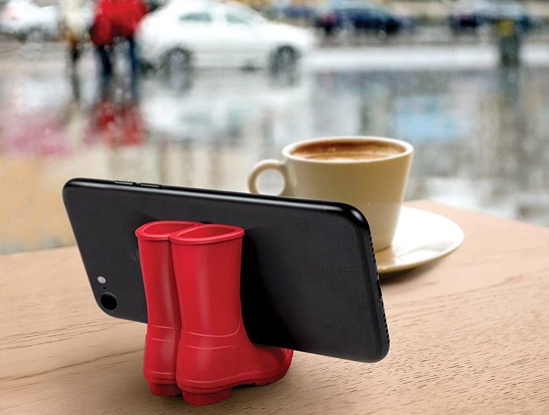 the red rain boots holding a phone
