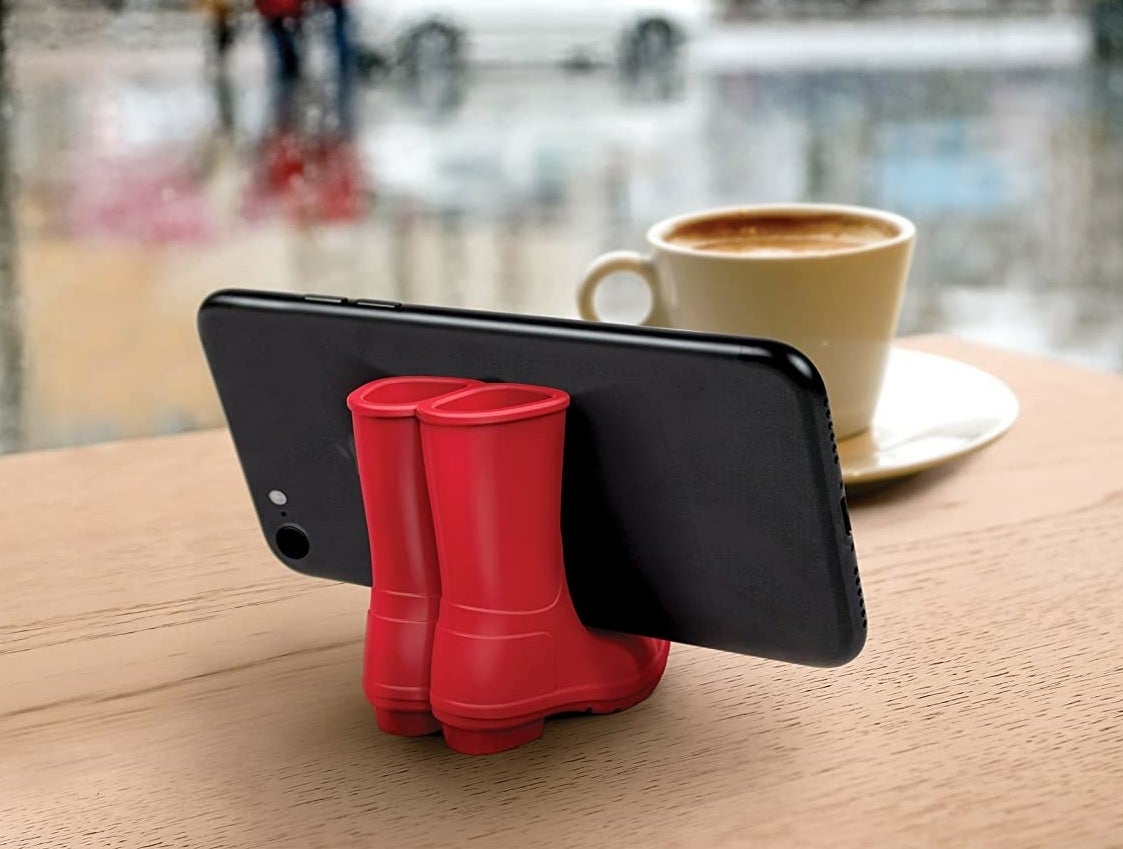 the red rain boots holding a phone