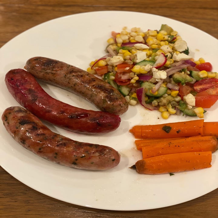 Three kinds of Seemore's sausages on a plate with carrots and corn salad.