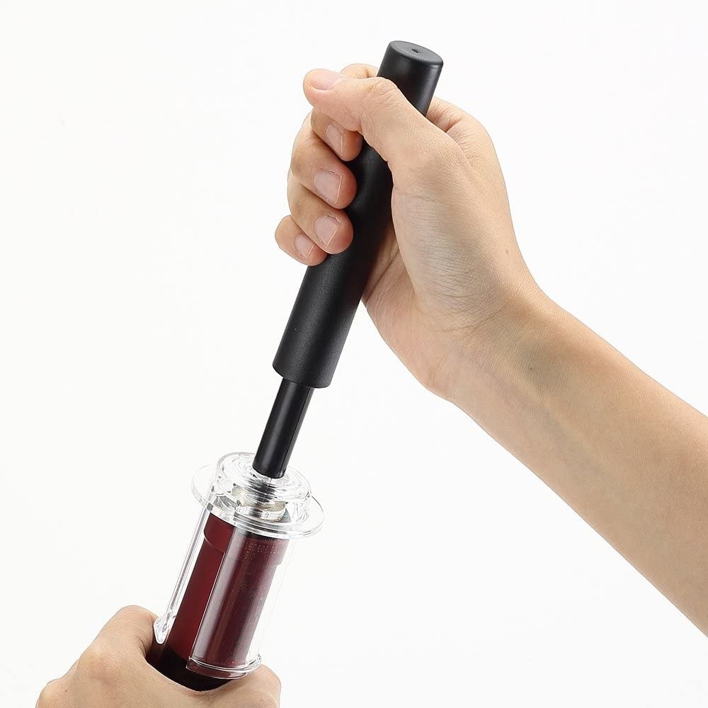 Hand using the wine opener on a bottle of wine 