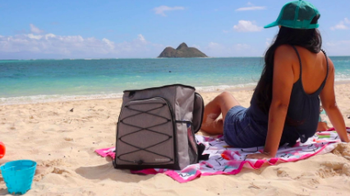 Same reviewer shows front side of the cooler, which has bungee detailing, while relaxing at the beach