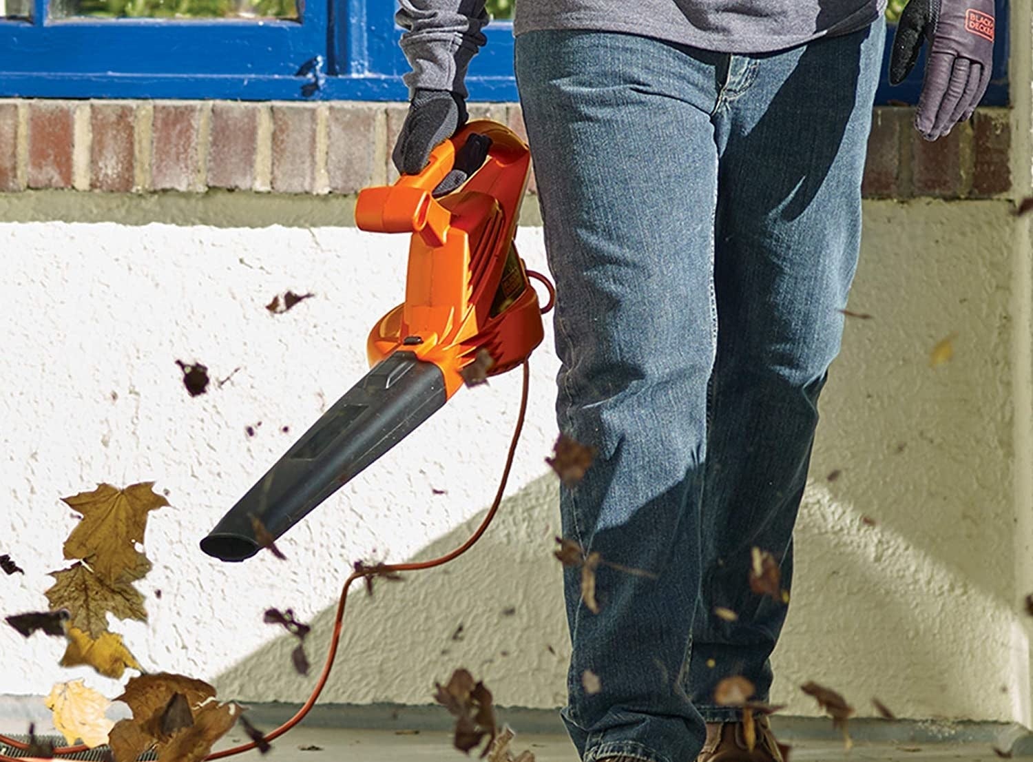 a model holding the leaf blower with an orange handle