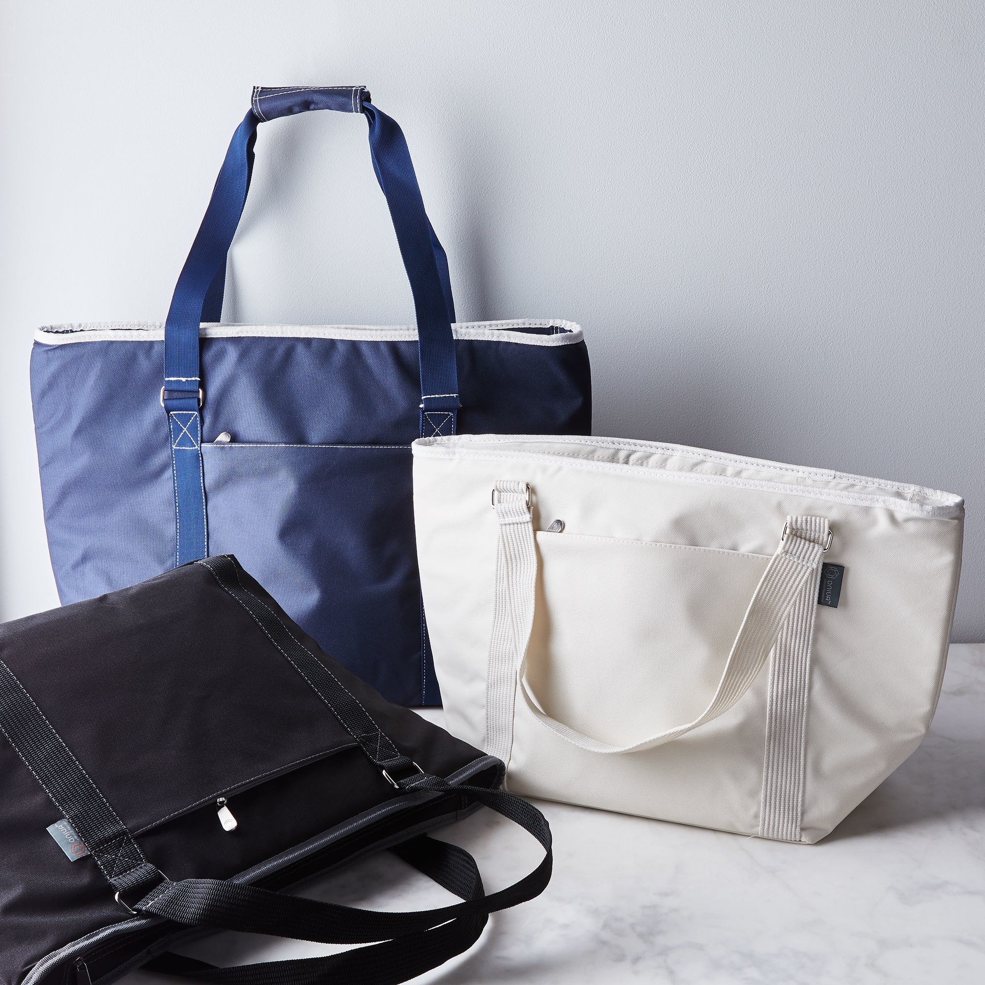 Blue, black, and white cooler tote bags grouped together 