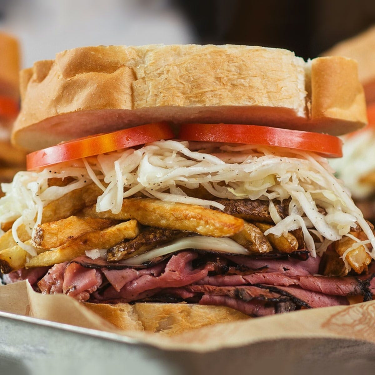 White bread stuffed with pastrami, coleslaw, fries, and sliced tomato from Primati Bros.