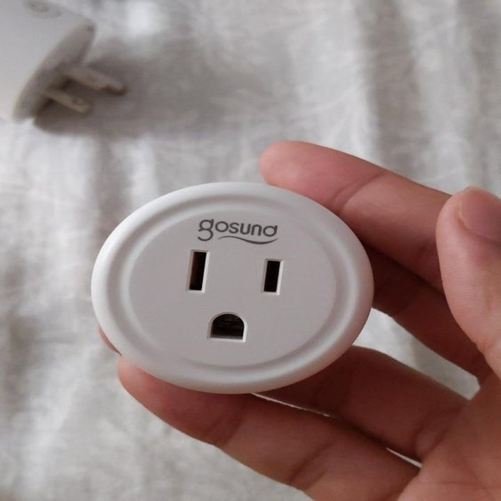 Reviewer holding the smart plug 
