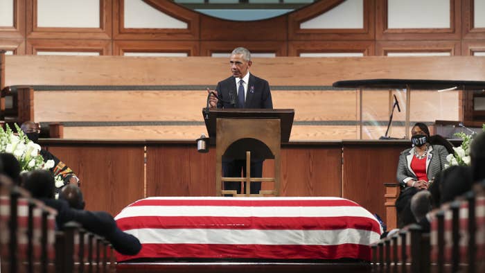 Barack Obama speaks from a lectern while standing above John Lewis&#x27;s coffin, which is draped in a US flag