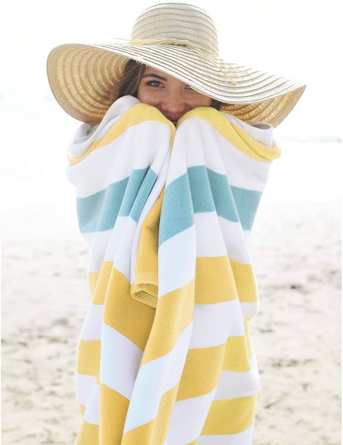 Model wrapped in a yellow, white and sea-glass striped towel 