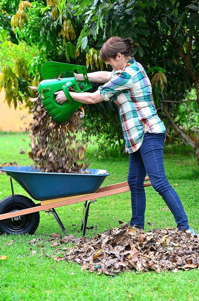 a model using the oversized plastic gloves to pick up massive piles of leaves without a rake