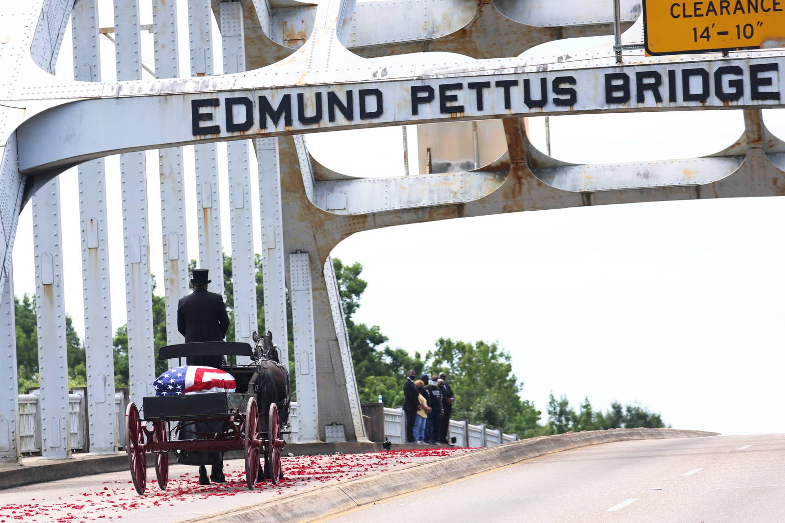 A horse-drawn carriage carrying the remains of John Lewis crosses the Edmund Pettus Bridge in Selma, Alabama