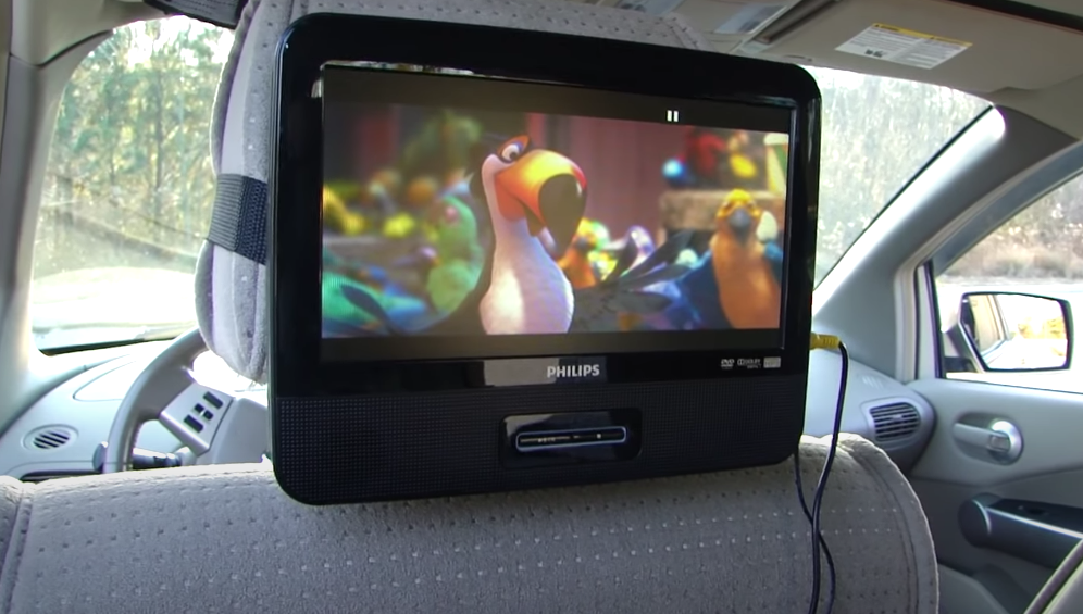 A portable screen attached to the back of the drivers seat.