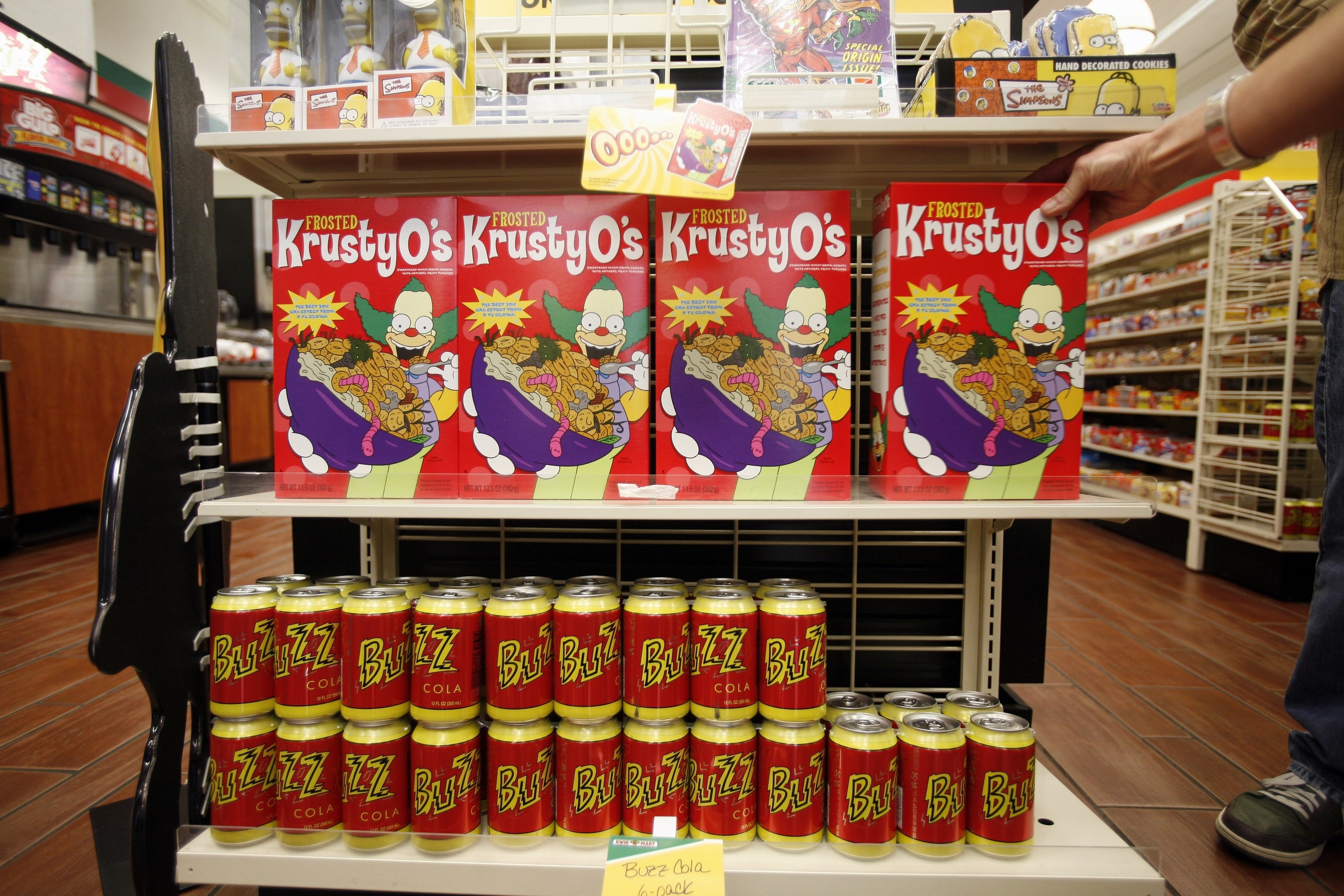 A shelf inside a 7-Eleven selling Krusty O&#x27;s and Buzz Cola.