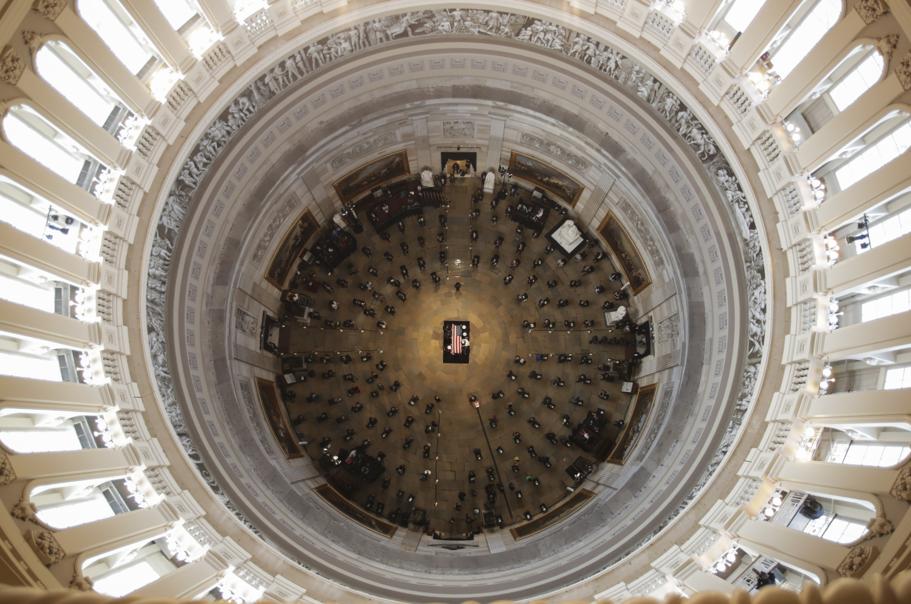 An aerial view looks down at the Capitol rotunda, with the casket at the center of the room and attendees sitting around it