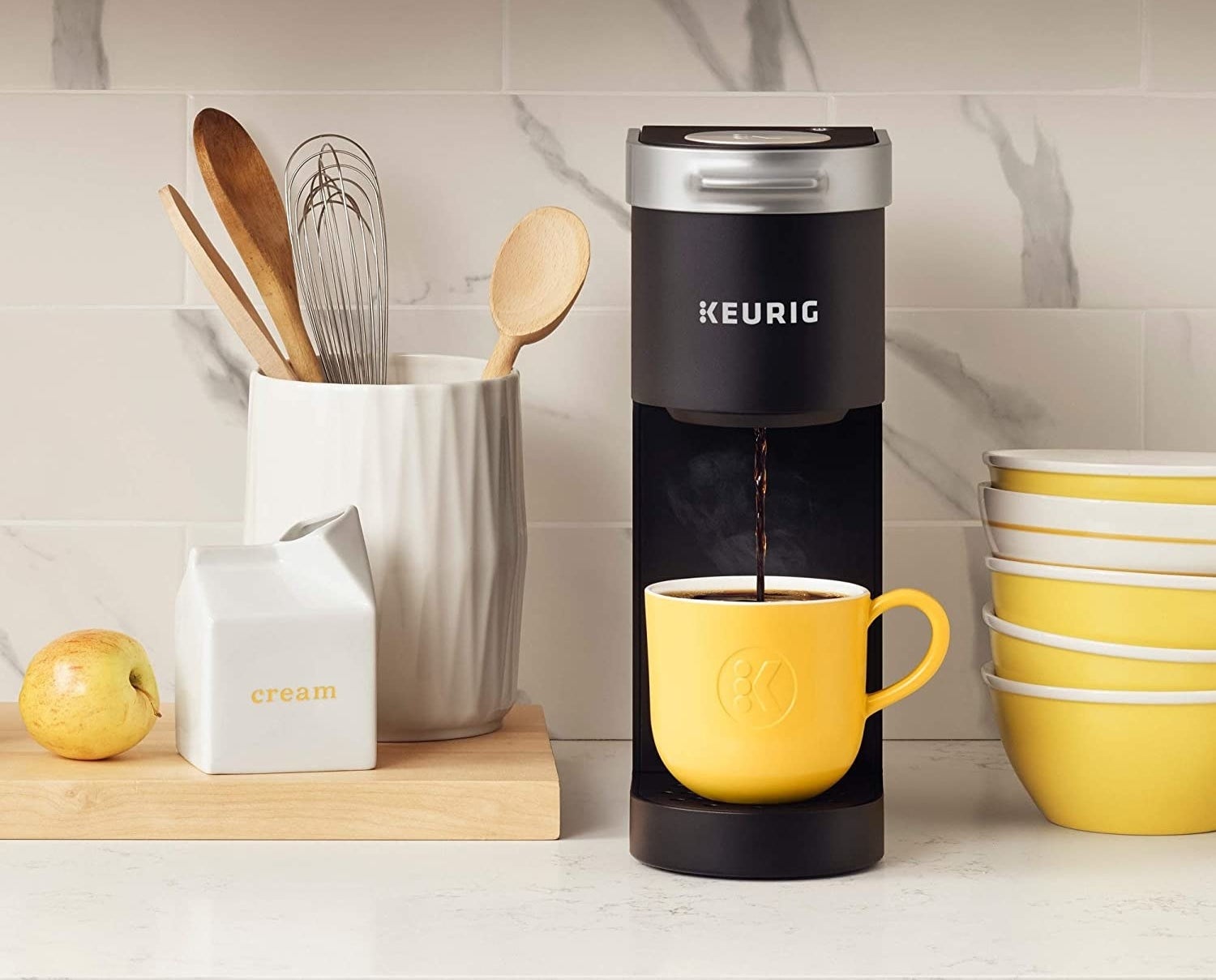 The slim machine dispensing coffee into a mug