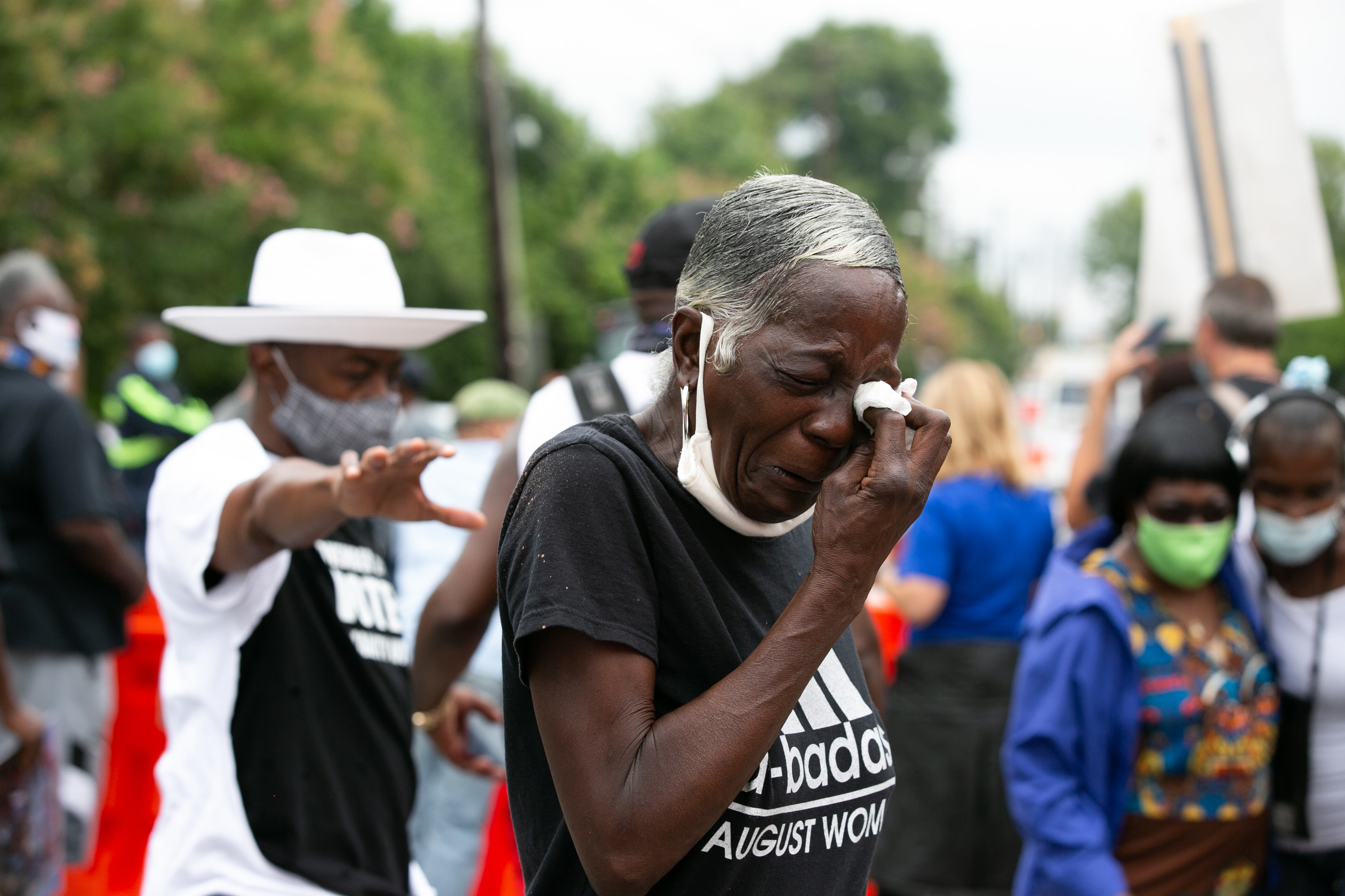 A crying woman holds a tissue to her eyes and wipes tears