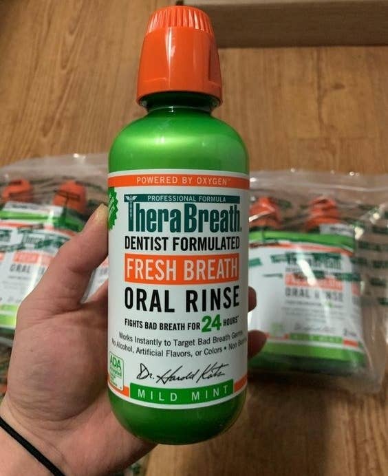 Hand holding the large bottle of oral rinse 
