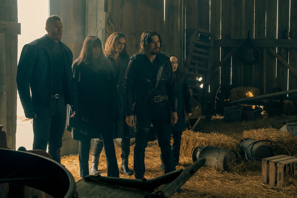 The cast of The Umbrella Academy stands in a barn.